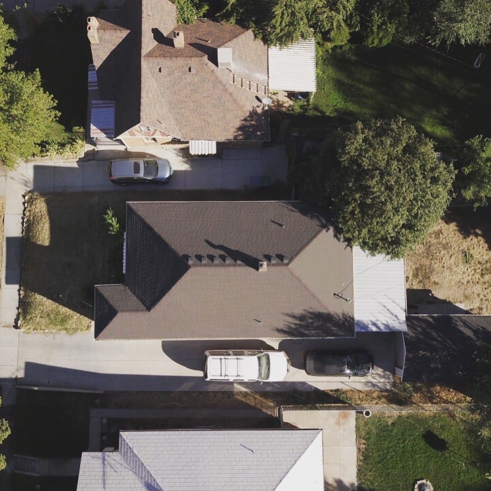 Aerial view of newly installed dark architectural shingle roof on a Utah residential home
